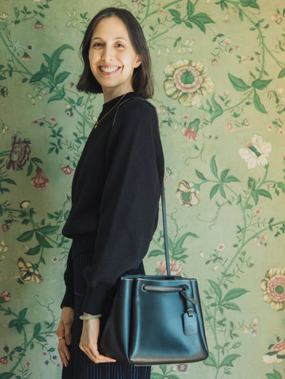 Smiling woman holding a shoulder bag