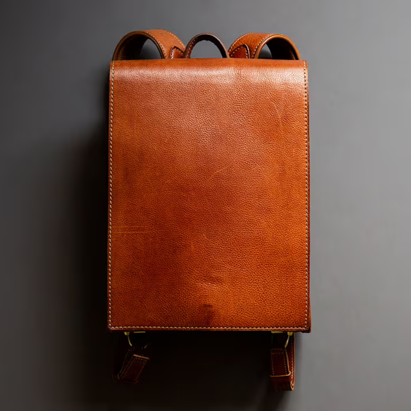 Brown leather backpack on a gray background